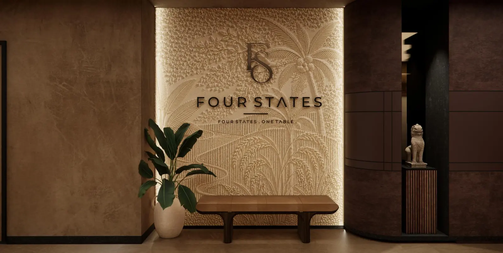 A plaster wall carved in low relief with palms, paddy and banana leaves around the Four States monogram, above a timber bench